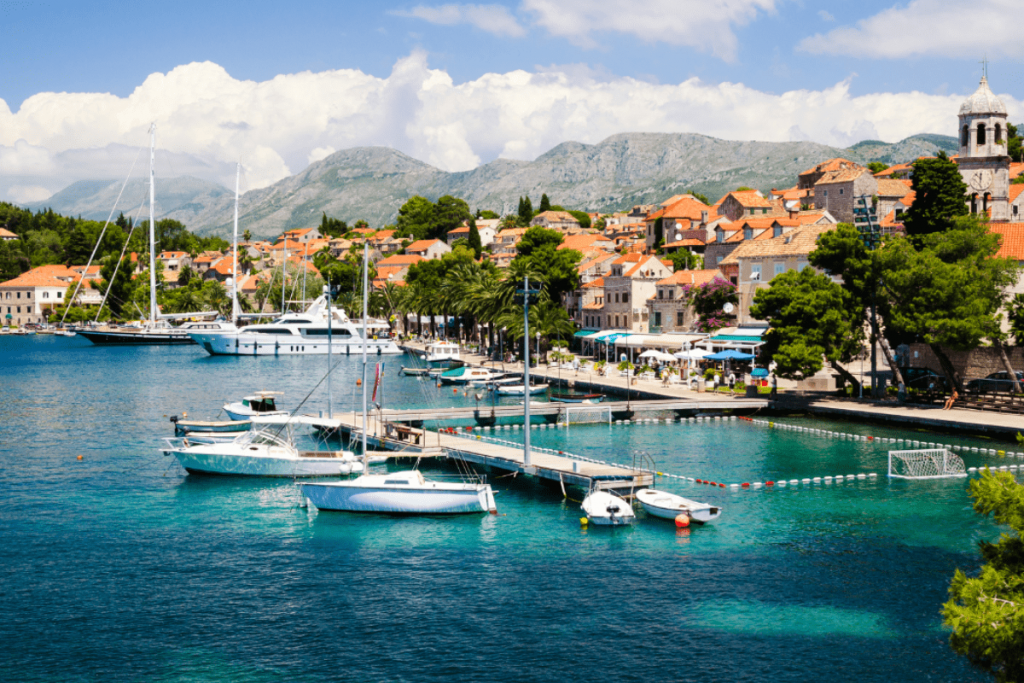 Auswandern nach Kroatien – Malerischer Hafen in Kroatien mit Yachten, Altstadt und türkisblauem Meer.