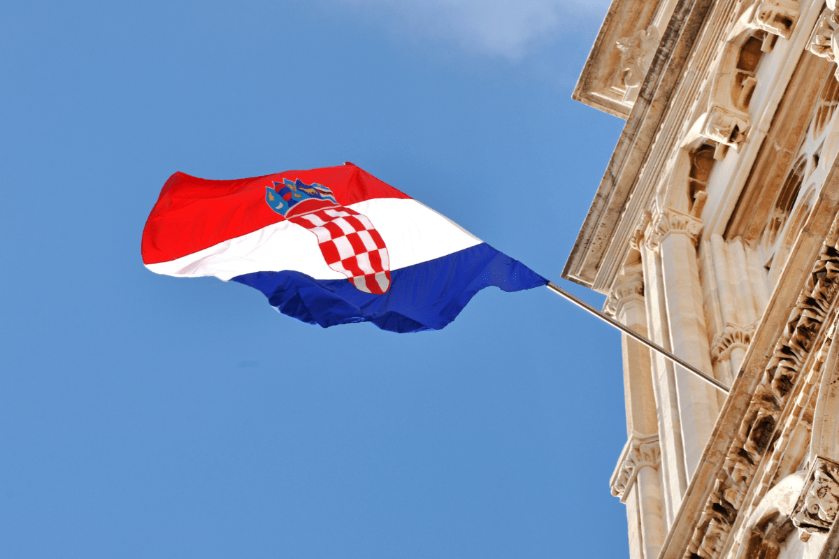 Kroatische Flagge weht an einem historischen Gebäude – Symbolisch für Auswandern nach Kroatien.