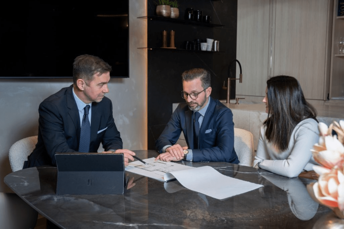 Dino Pesa – Gründer von Seaview Real Estate bespricht mit zwei weiteren Personen einen Grundrissplan